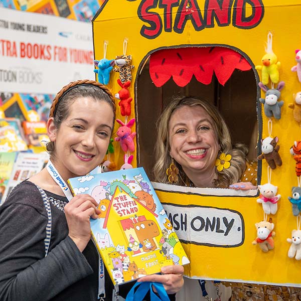A female attendee holding a book and an exhibitor in a cutout display at TLA 2026 Annual Conference.