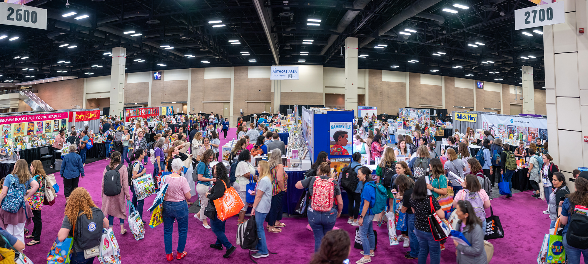Wide shot of the TLA Exhibit Hall with attendees and booths