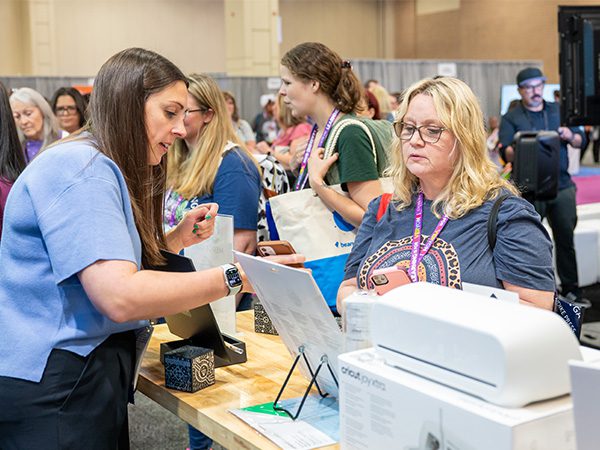 Exhibitor demonstrating to TLA attendee in the exhibit hall