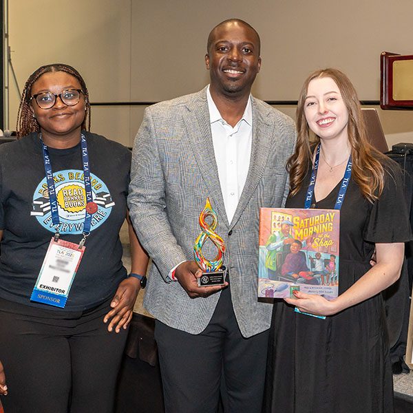 Keenan Jones Black Caucus Round Table award winner with two women at TLA Annual Conference.