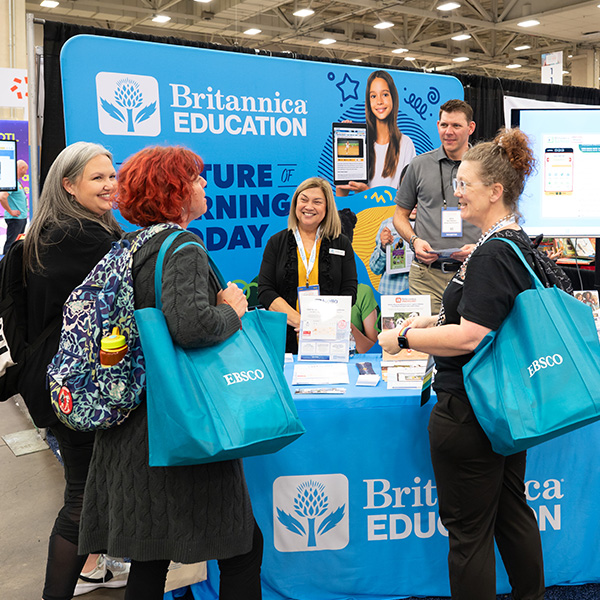 TLA 2025 Exhibit Hall Booth with three attendees talking with vendors