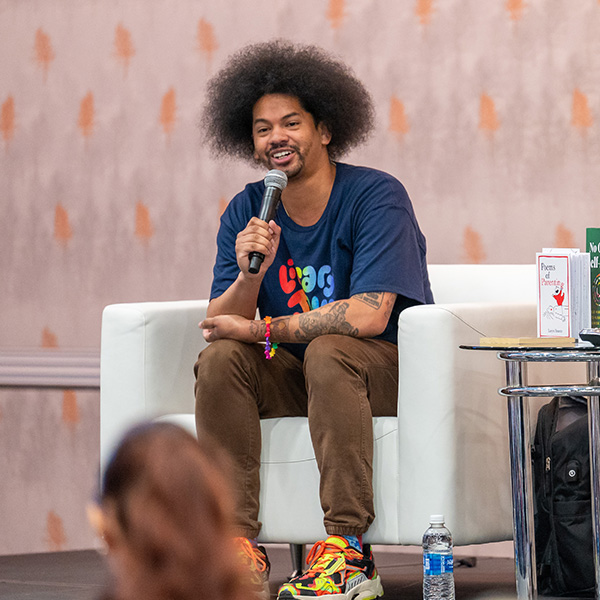 TLA 2025 Speaker - Mychal Threets onstage in a chair speaking