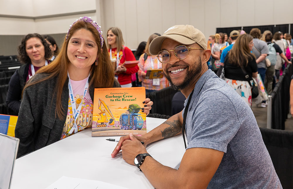Attendee getting booked signed with author in the TLA Authors Area