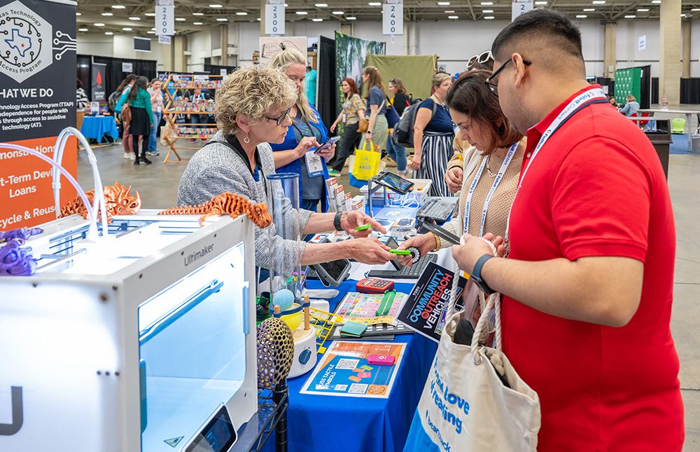 Two TLA Annual Conference attendees at booth with exhibitor